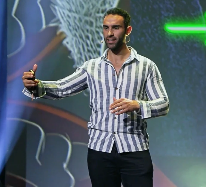 Lucas Aoun speaking on stage at an international conference